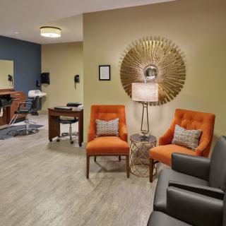 A cozy waiting room with bright orange chairs and stylish decor.