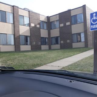 A view of a multi-unit residential building with handicap parking signage.