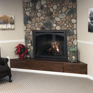 A cozy living room with a stone fireplace and comfortable seating.