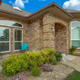 A beautiful brick house with well-maintained landscaping and large windows.