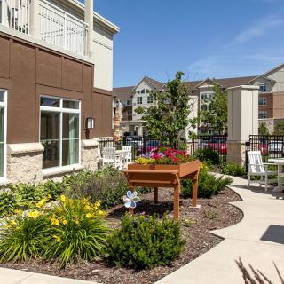 A well-maintained community garden area with planter boxes in an apartment complex.
