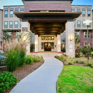 A modern building entrance with a landscaped pathway leading to its doors.