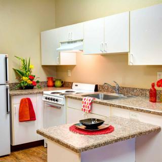 A modern kitchen with white cabinets and colorful decor.