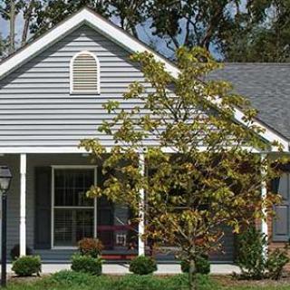 A charming residential house with a porch and front yard.