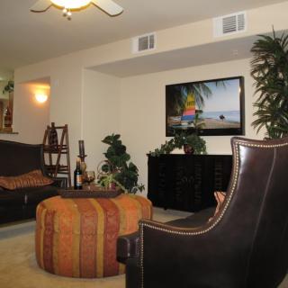 A cozy living room with modern furniture and a television mounted on the wall.
