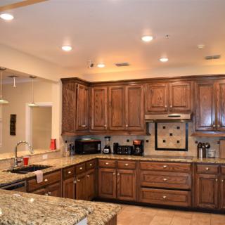A spacious kitchen featuring wooden cabinets, granite countertops, and modern appliances.