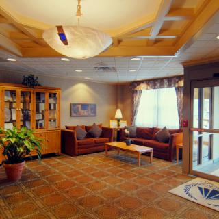 A cozy lobby with comfortable seating, warm lighting, and decorative elements.