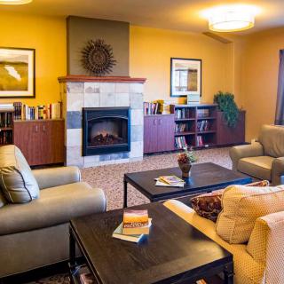 A cozy living room with sofas, a fireplace, and bookshelves.