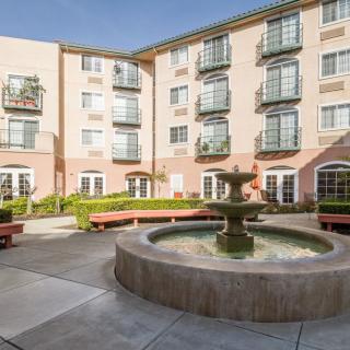 A serene courtyard with a central fountain surrounded by residential apartments.