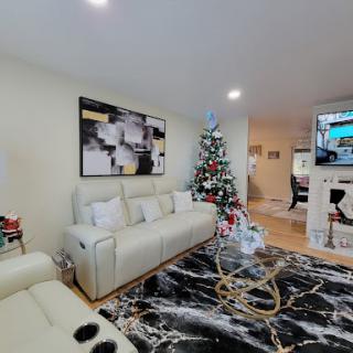 A cozy living room adorned with a Christmas tree and modern furnishings, perfect for holiday gatherings.