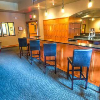 A cozy bar interior with a row of high stools lined up at the counter.