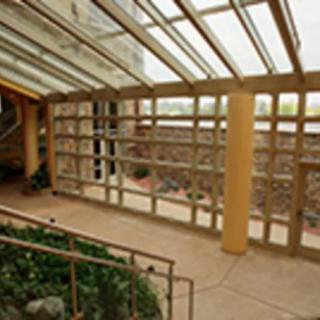 A modern interior space featuring a glass ceiling and wooden beams, allowing ample natural light.