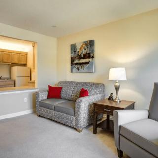 A cozy living room with a patterned sofa, armchair, and a warm lamp.