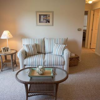 A cozy living room featuring a striped sofa and a glass-topped coffee table.