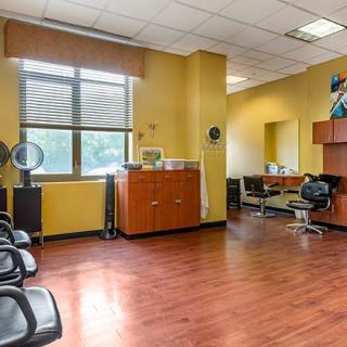 A modern hair salon interior with chairs, mirrors, and wooden flooring.