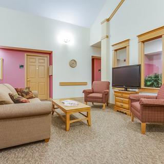 A cozy living room with a sofa, armchairs, and a television.