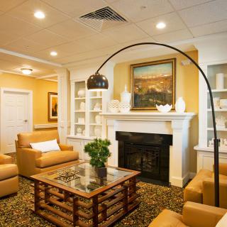 A cozy living room with a fireplace, comfortable sofas, a stylish coffee table, and elegant decor.