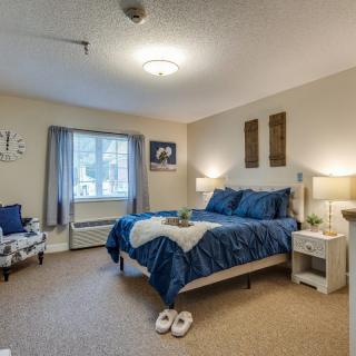 A cozy bedroom with blue bedding and warm lighting.