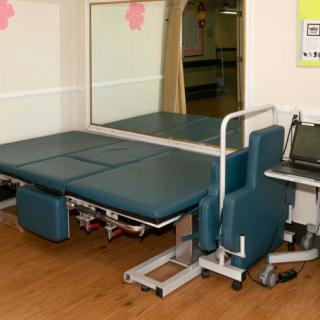 A physical therapy room with a specialized therapy table and equipment.