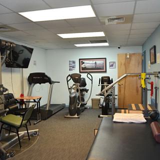 A small gym room with exercise equipment including treadmills and an exercise bike.