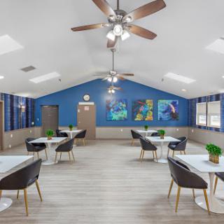A vibrant community room featuring modern furniture, artistic decor, and a spacious layout.