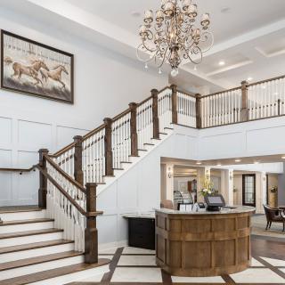 Elegant hotel lobby featuring a grand staircase and a chandelier.