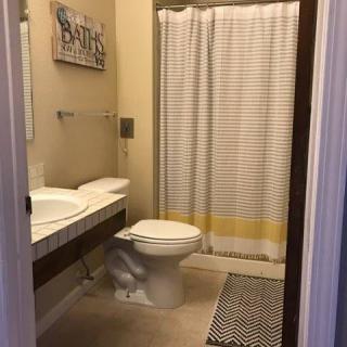 A clean and well-arranged bathroom with a toilet, sink, and shower.