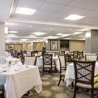 An elegant dining room with set tables and chairs, ready for guests.