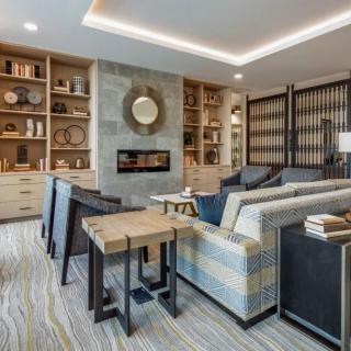 A modern living room with stylish decor, featuring a fireplace and built-in bookshelves.