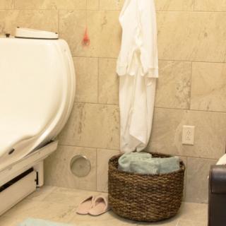 A cozy bathroom with a white bathtub and neatly arranged towels in a basket.