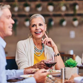 A group of adults enjoying a meal and conversation at a restaurant.