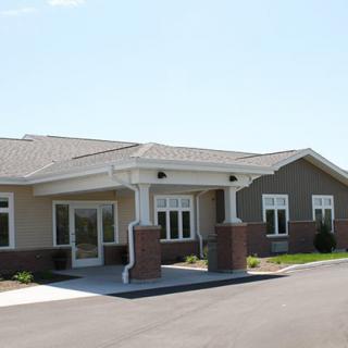 A modern building with a covered entrance and large windows.