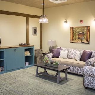 A cozy living room featuring floral patterned furniture, a rustic coffee table, and tasteful decor.