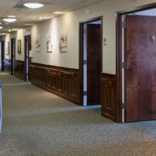A quiet office hallway with several closed doors along the corridor.