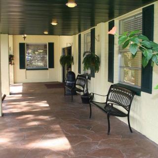 A cozy porch with benches and plants.