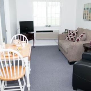 A cozy living room with a dining table, sofa, and television.