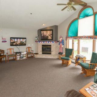 A cozy living room with a fireplace, large window, and comfortable seating.