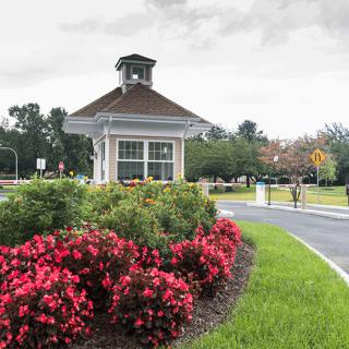 A scenic view featuring a landscaped garden with vibrant flowers and a small gazebo structure.