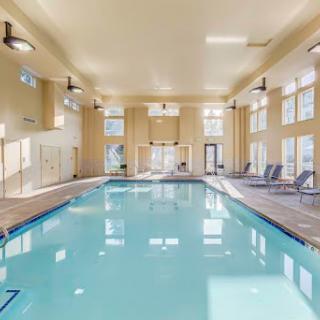 A spacious and inviting indoor swimming pool area with large windows and comfortable seating.