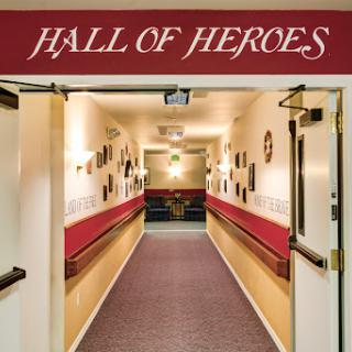 The entrance to the Hall of Heroes, showcasing a decorated hallway filled with art and recognition.