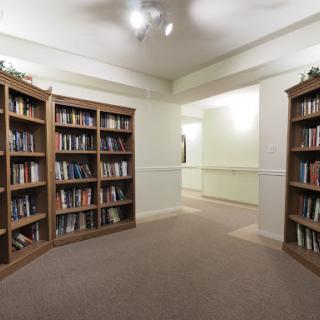 A cozy library corner with wooden bookshelves filled with various books.