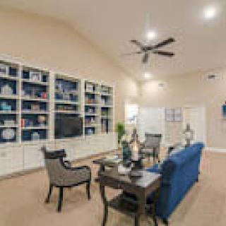 A spacious living room featuring modern furniture, built-in bookshelves, and tasteful decor.