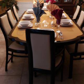 A formal dining table setup with neatly arranged dinnerware and decorative napkins.