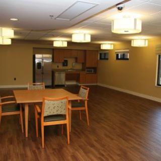 A modern kitchen and dining area with wooden flooring and contemporary lighting.