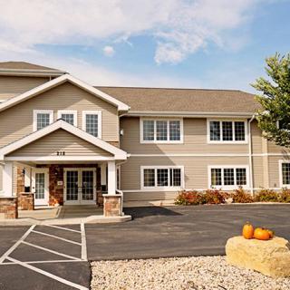 A residential building with pumpkins placed outside, indicating an autumn setting.