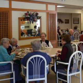A group of seniors enjoying a meal together in a cozy restaurant setting.