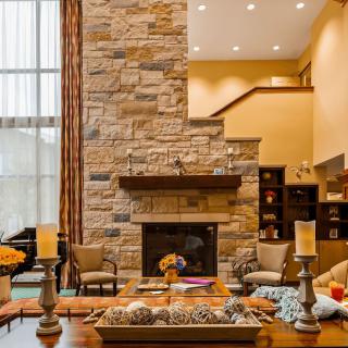 A modern living room with a stone fireplace and cozy decor.