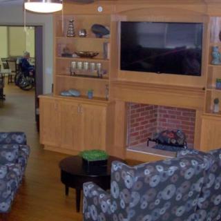 A cozy living room with a brick fireplace and wall-mounted television.