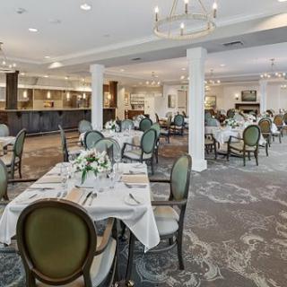 An elegant dining room set with tables and chairs, showcasing a sophisticated interior design.