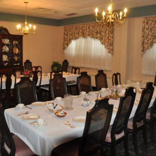 An elegant dining room with a formal table setting and chandeliers.